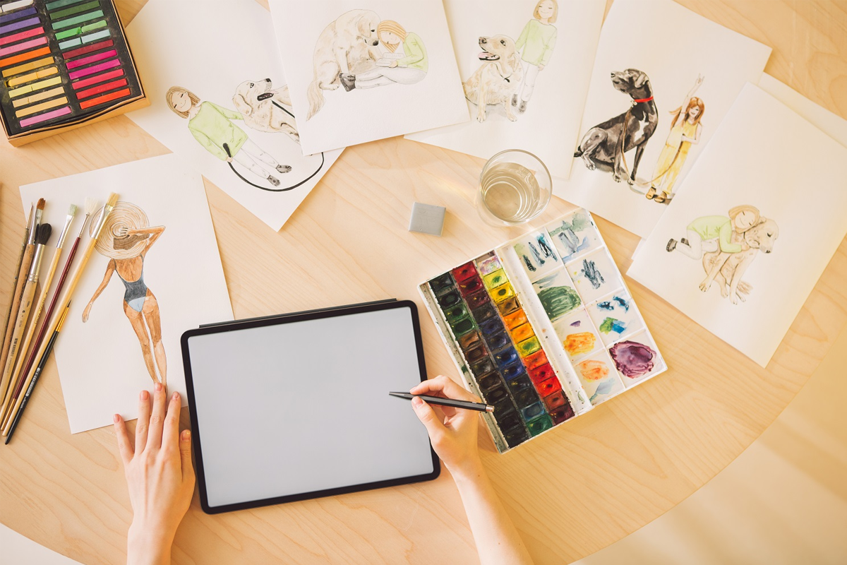 一位創意插畫家在桌上設計插畫作品，用色盤和水彩筆進行顏色創作，桌上擺滿插畫紙和顏料。