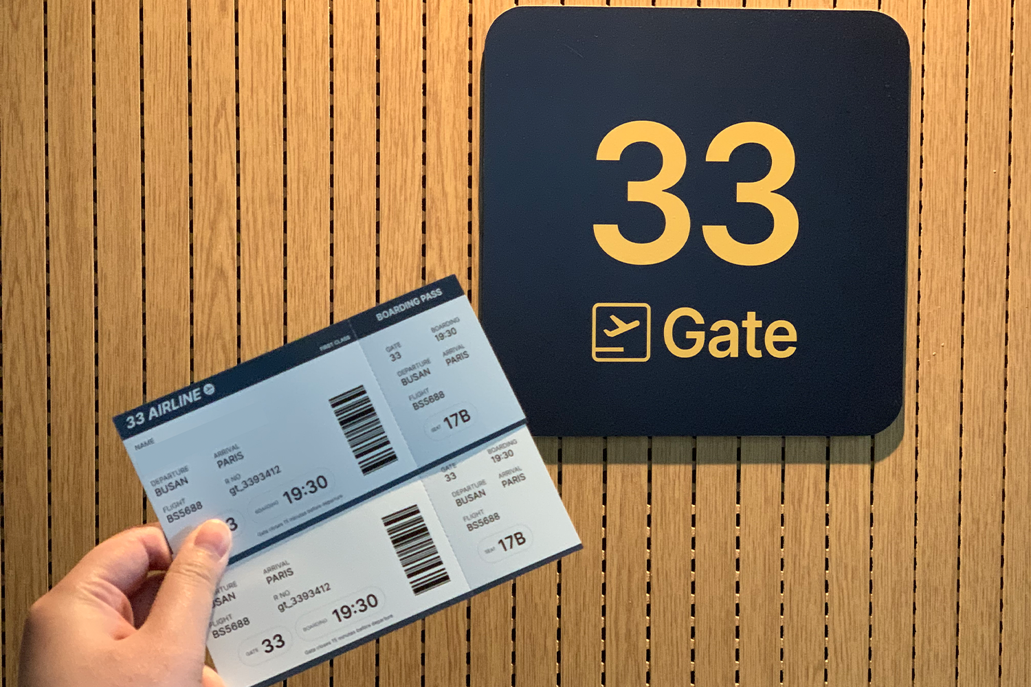 持有模擬登機牌的手，背景為33 Gate標誌，呈現航空主題咖啡館的特色。
