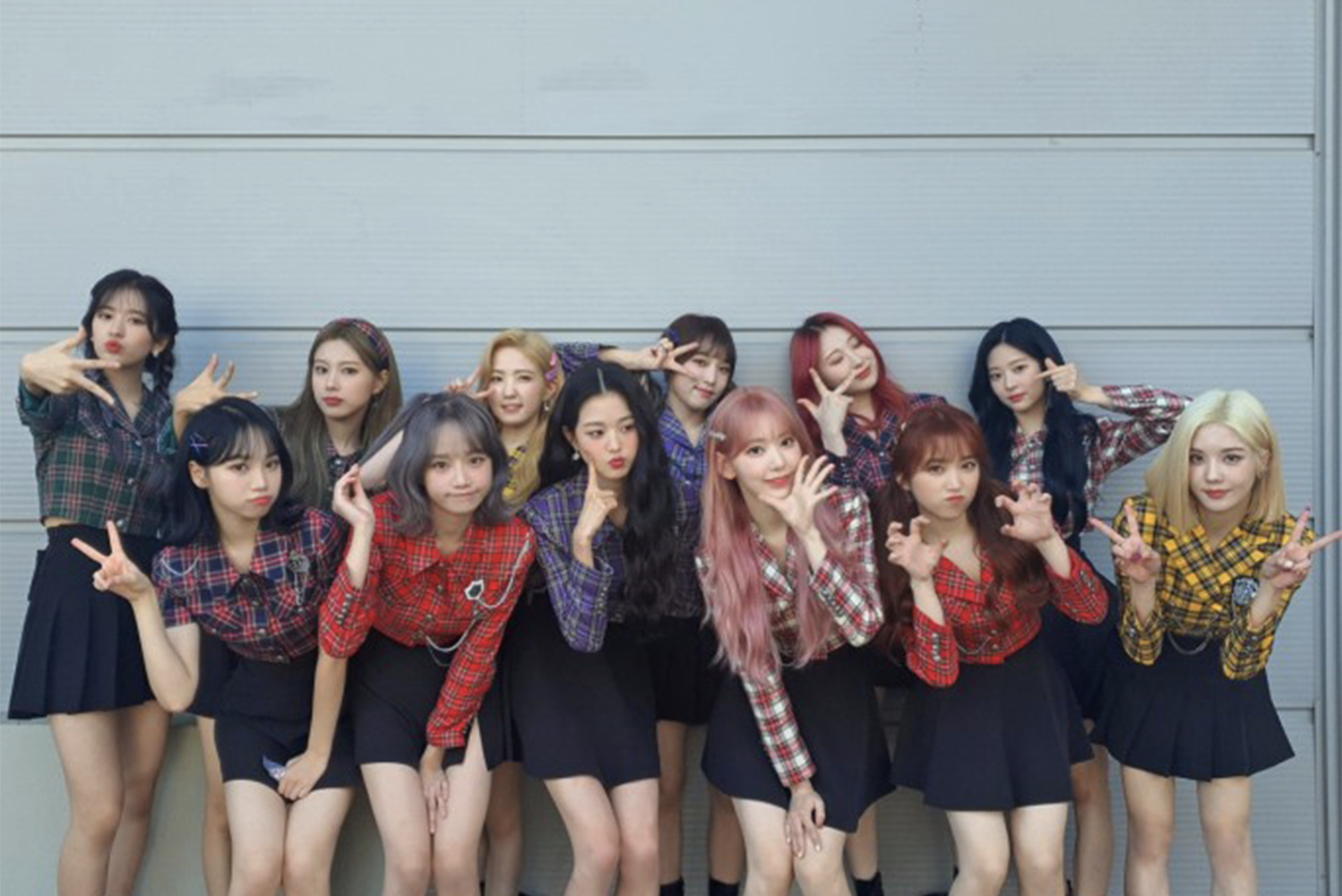 IZ*ONE 於排練中展示活力和幽默感,穿著鮮豔的格子襯衫和黑色裙子,展現青春活潑的形象。