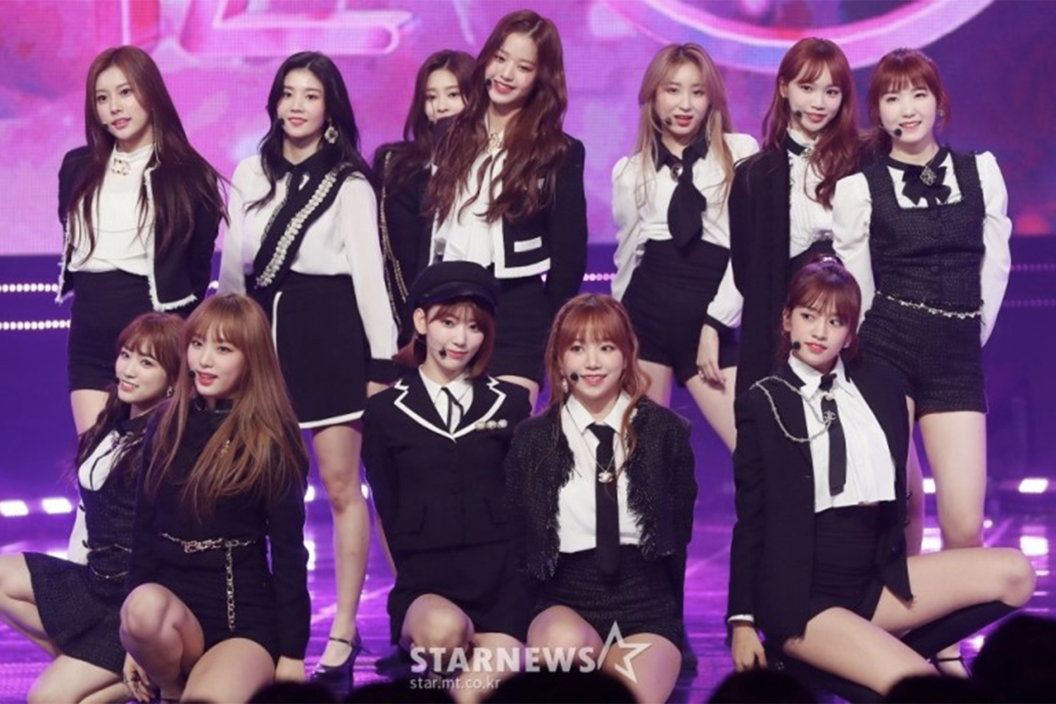 IZ*ONE 在舞台上進行華麗的表演,穿著統一的黑白服裝,展現專業自信的風格。