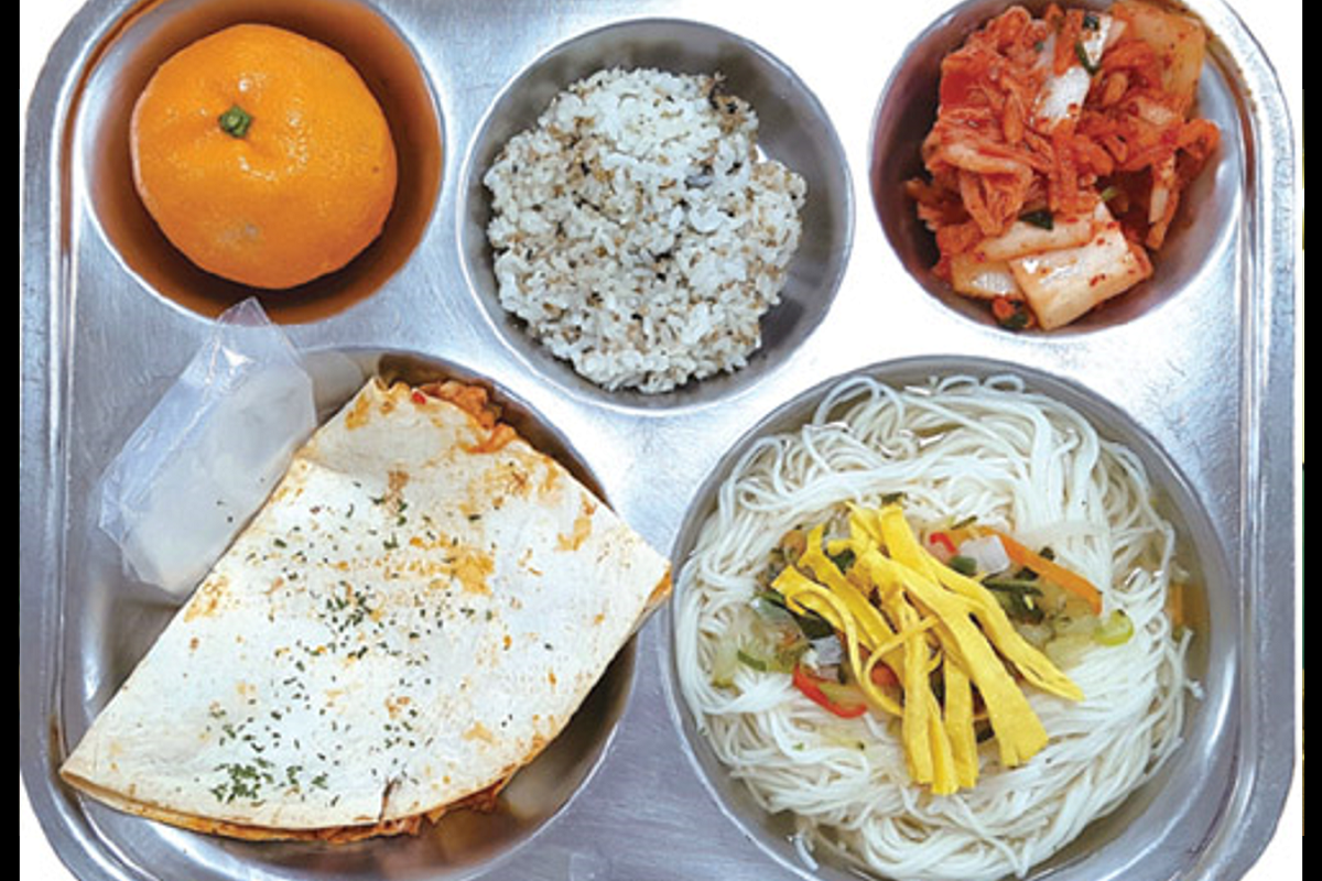 營養午餐，包含米飯、泡菜、豆腐、湯和其他配菜，展示韓國學校提供的膳食選項。