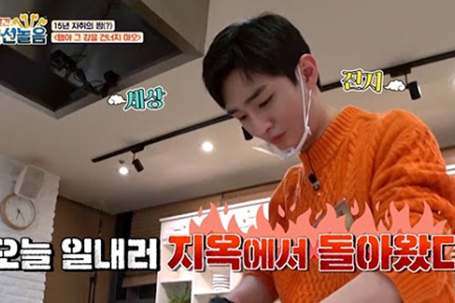 尹智聖穿著橙色毛衣在節目中被稱為“地獄廚神”，背景是廚房，強調烹飪挑戰。