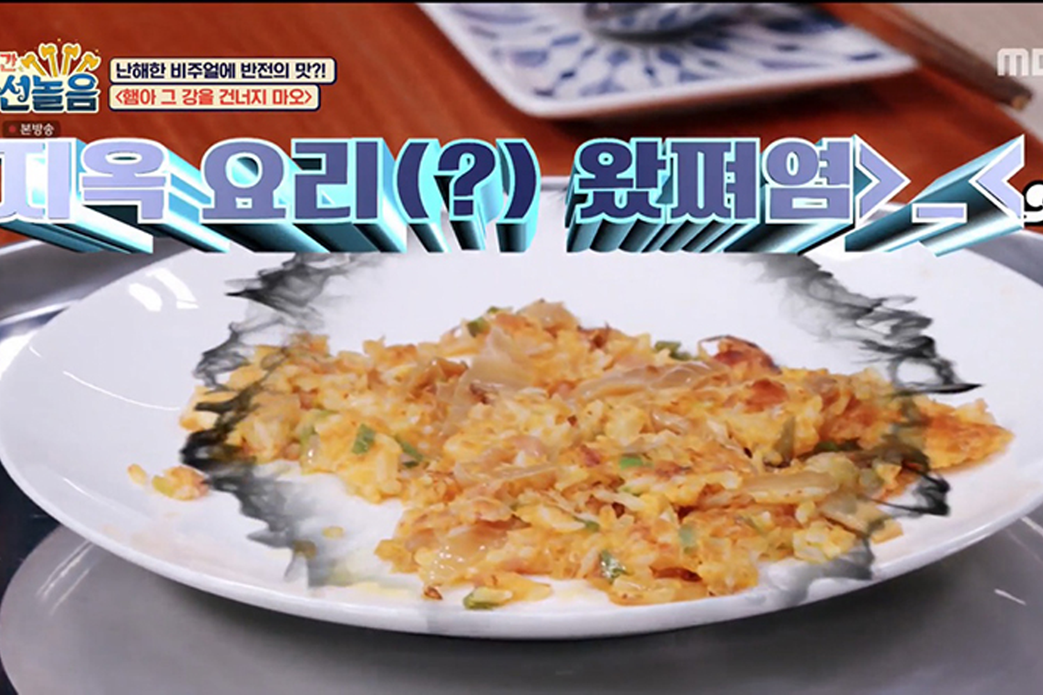 泡菜煎餅呈現在白色盤子上，盤面上有韓文字幕“地獄料理”，表達出菜餚的失敗之作。