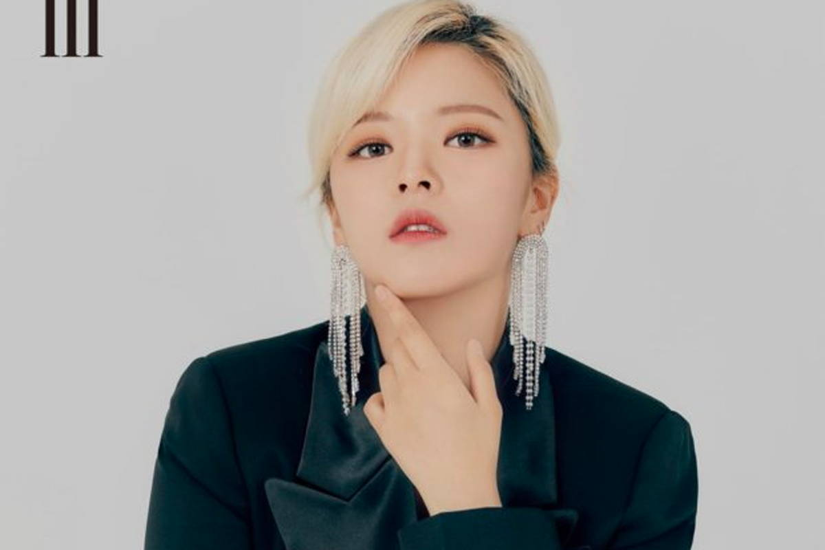 TWICE成員定延身穿黑色西裝，戴著華麗的長型耳環，手放在下巴上擺出優雅的姿勢。