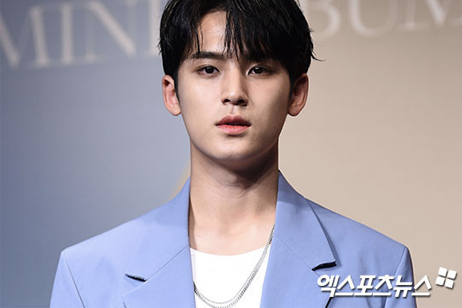 穿著藍色西裝展台上的男子，圖片來自拍攝的新聞活動。