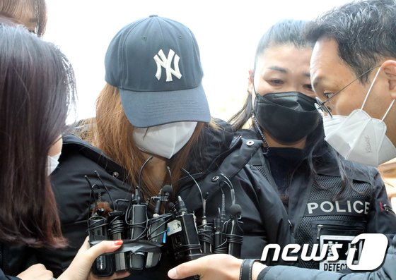 韩国三岁女童案件中，新闻报道中的相关人物被一群警察包围的场景，来源为news1