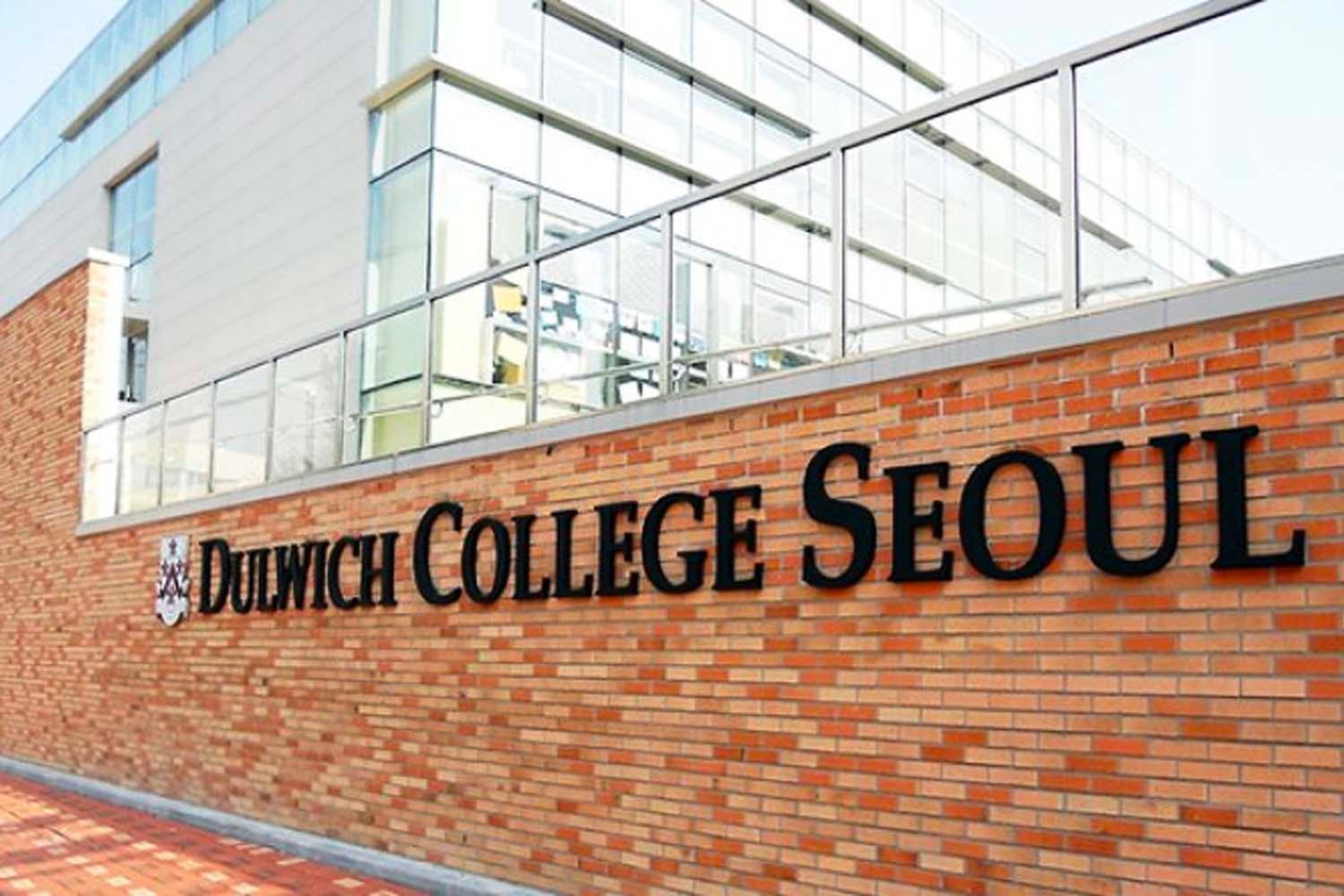 ทางเข้าโรงเรียน Dulwich College Seoul ที่มีป้ายกำแพงอิฐสีแดงเด่นชัดในเกาหลีใต้