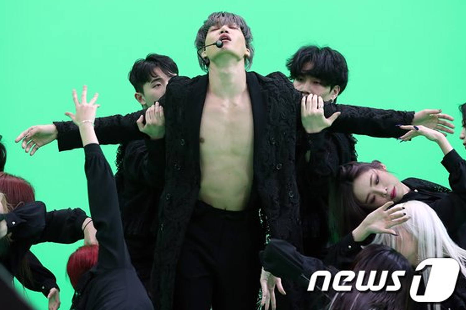 EXO Kai在綠色背景中，穿黑色服裝展示出舞蹈姿勢。