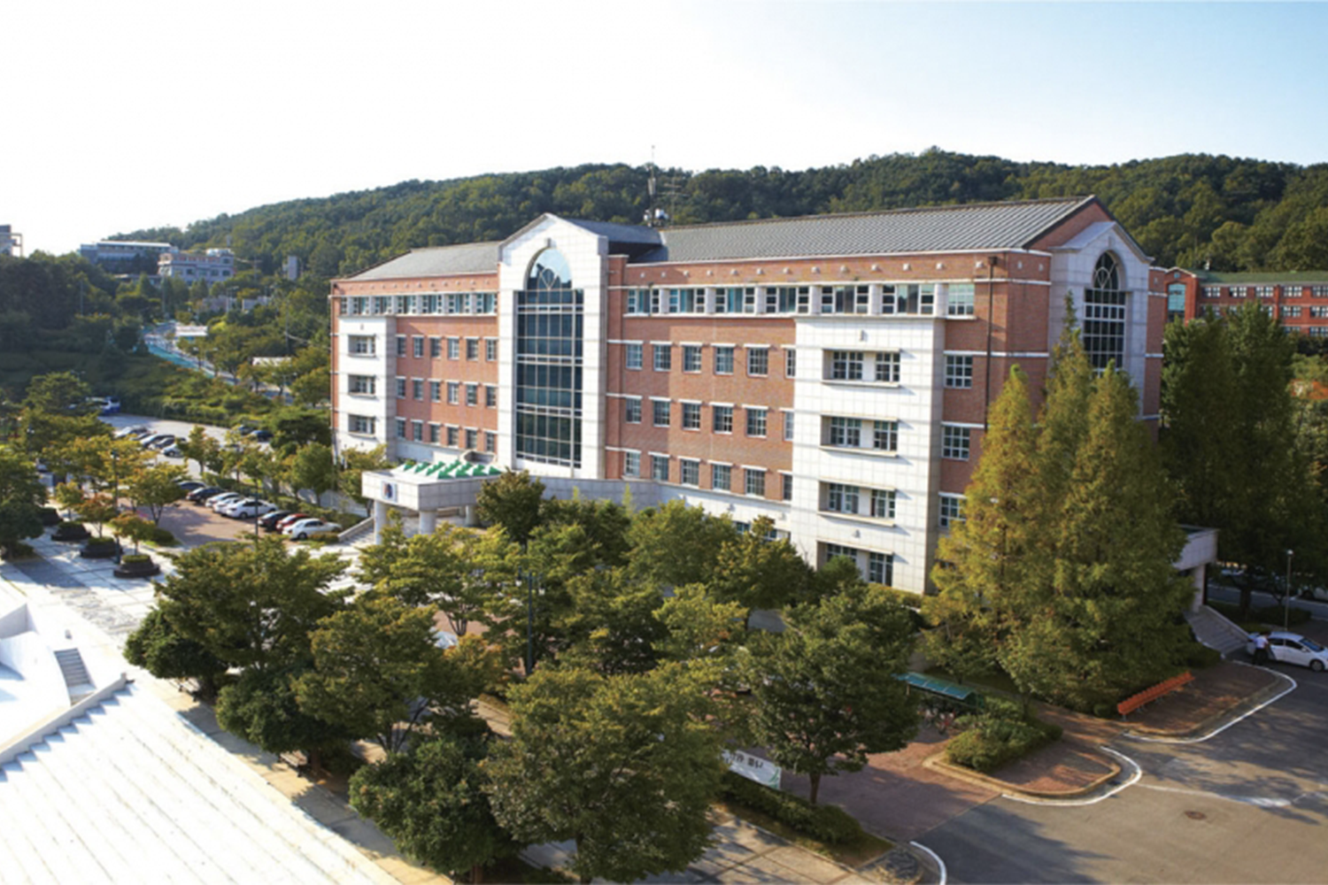 韩国国际大学的现代化教学楼，坐落于绿地和山林之间，象征着开创性的Kpop学系。来源：국제대학교。