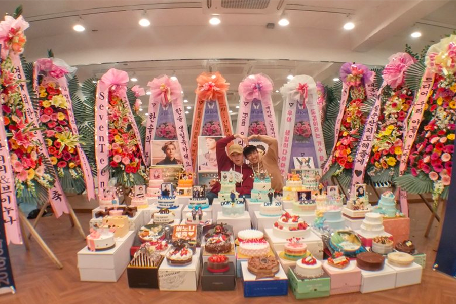 韓國粉絲送偶像的禮物呈列，花環和多層蛋糕組成場景