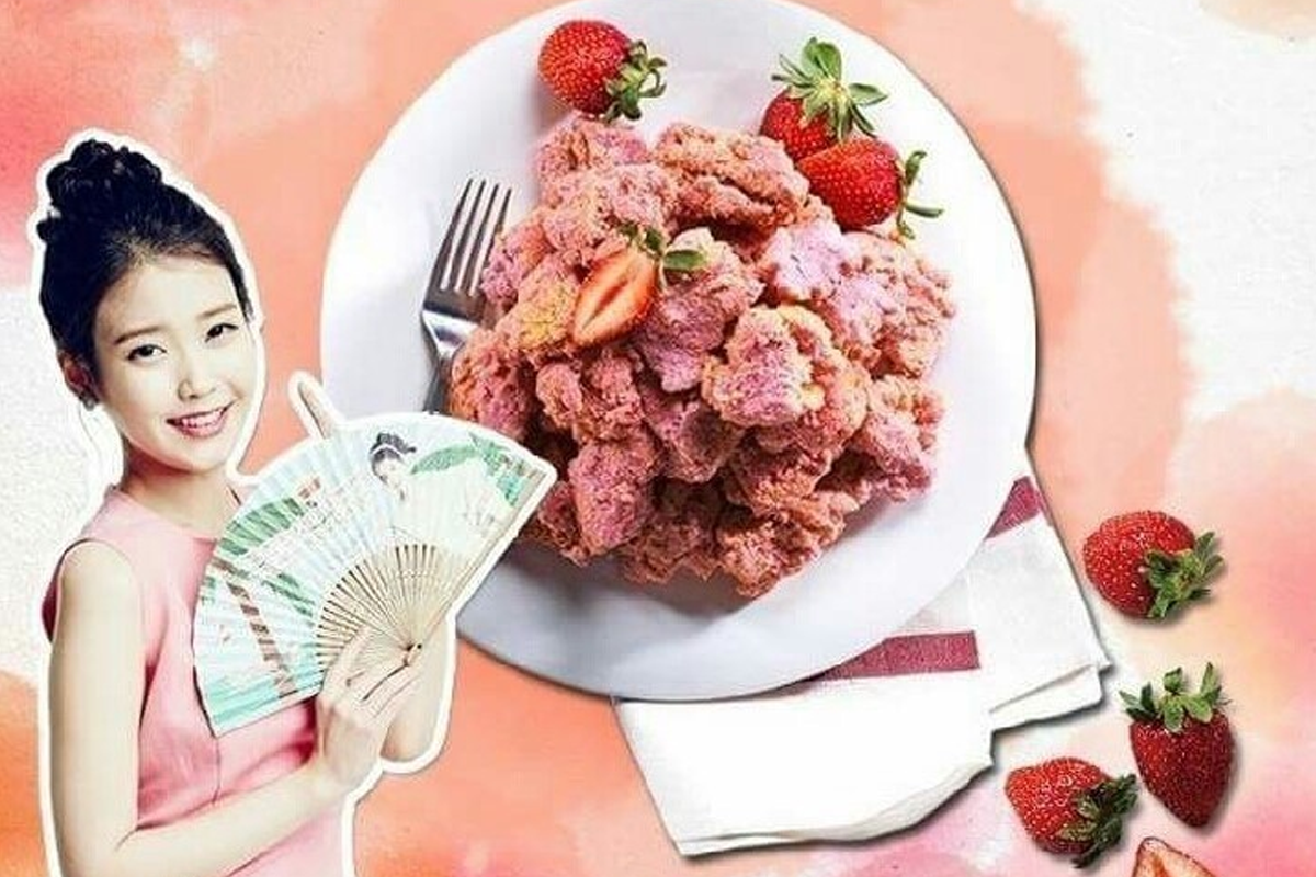 一盘草莓风味炸鸡，上面撒有草莓粉，周围点缀着新鲜草莓，背景色为柔和的草莓色，表现出水果风味的特殊性。