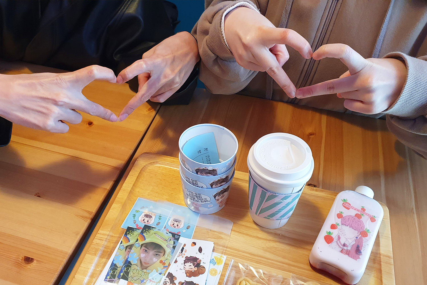 카페 테이블 위에 준비된 시우스트로베리 라떼 병과 XIUMIN 관련 이미지가 장식된 음료 병. 함께 제공되는 다른 기념품 모습.