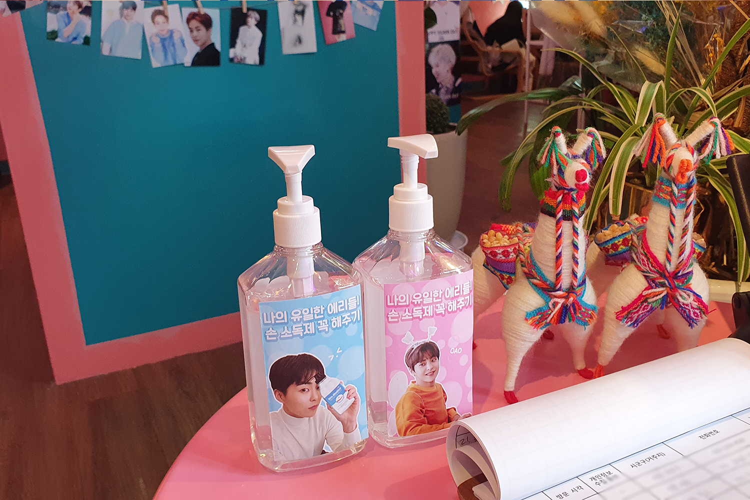 카페 내에 디스플레이된 손 소독제 병과 귀여운 장식품들. XIUMIN 관련 포스터가 배경에 보이는 모습.