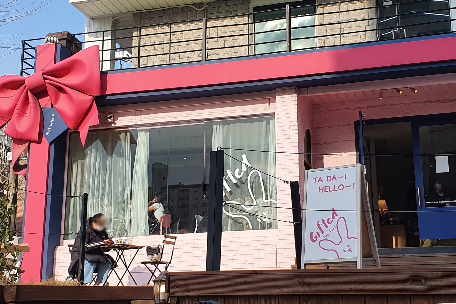 韓國ASATRO成員尹產賀的生日應援咖啡廳GIFTED的入口，由粉紅色裝飾和藍色門構成的可愛設計。