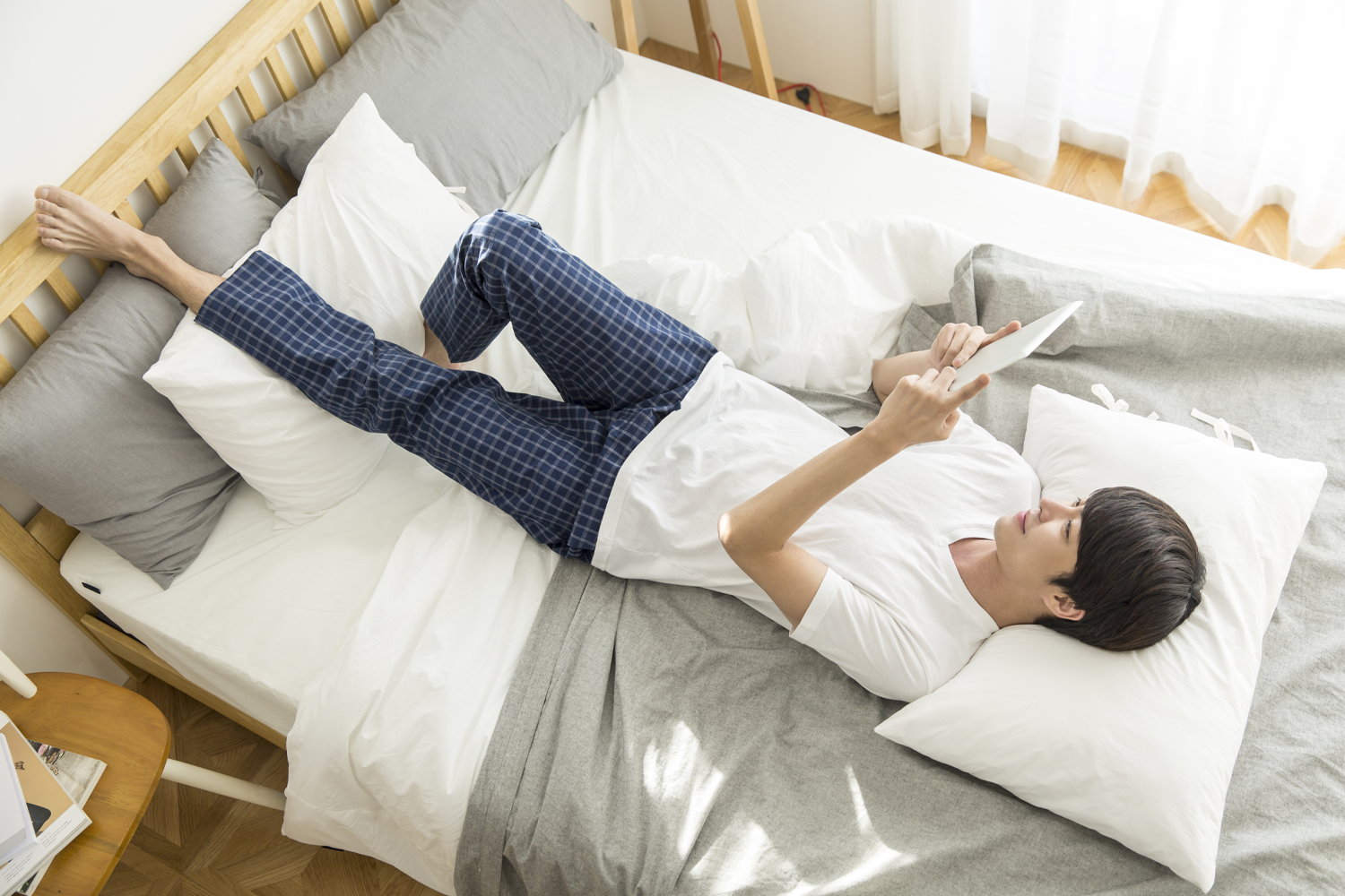 korean man tablet on bed