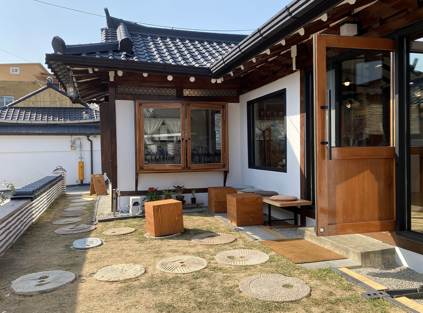 Mid-range, a tranquil hanok cafe in Korea, courtyard with wooden chairs