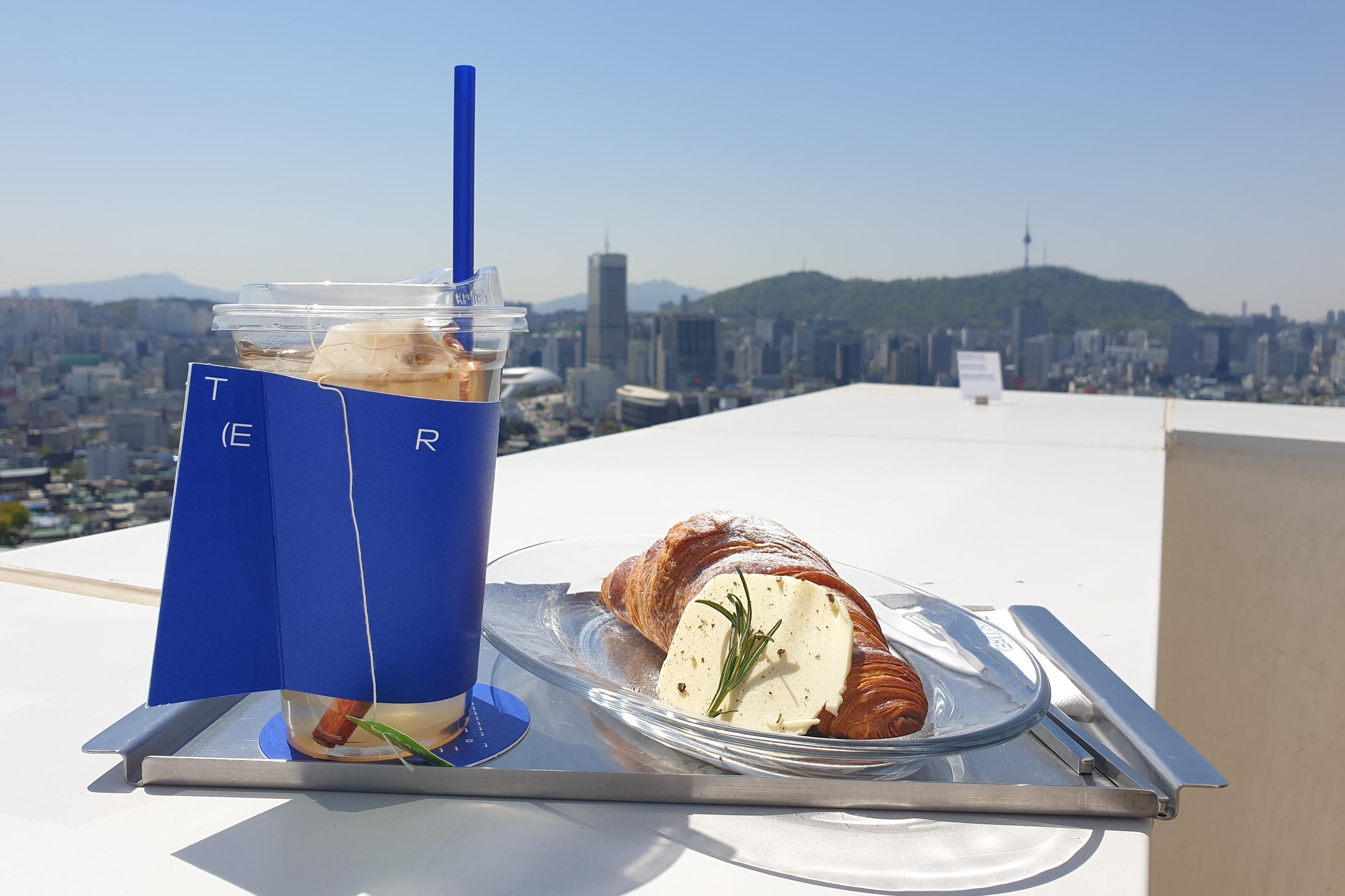 T(ER)T(RE) butter croissant and apple cinnamon drink on tray outside