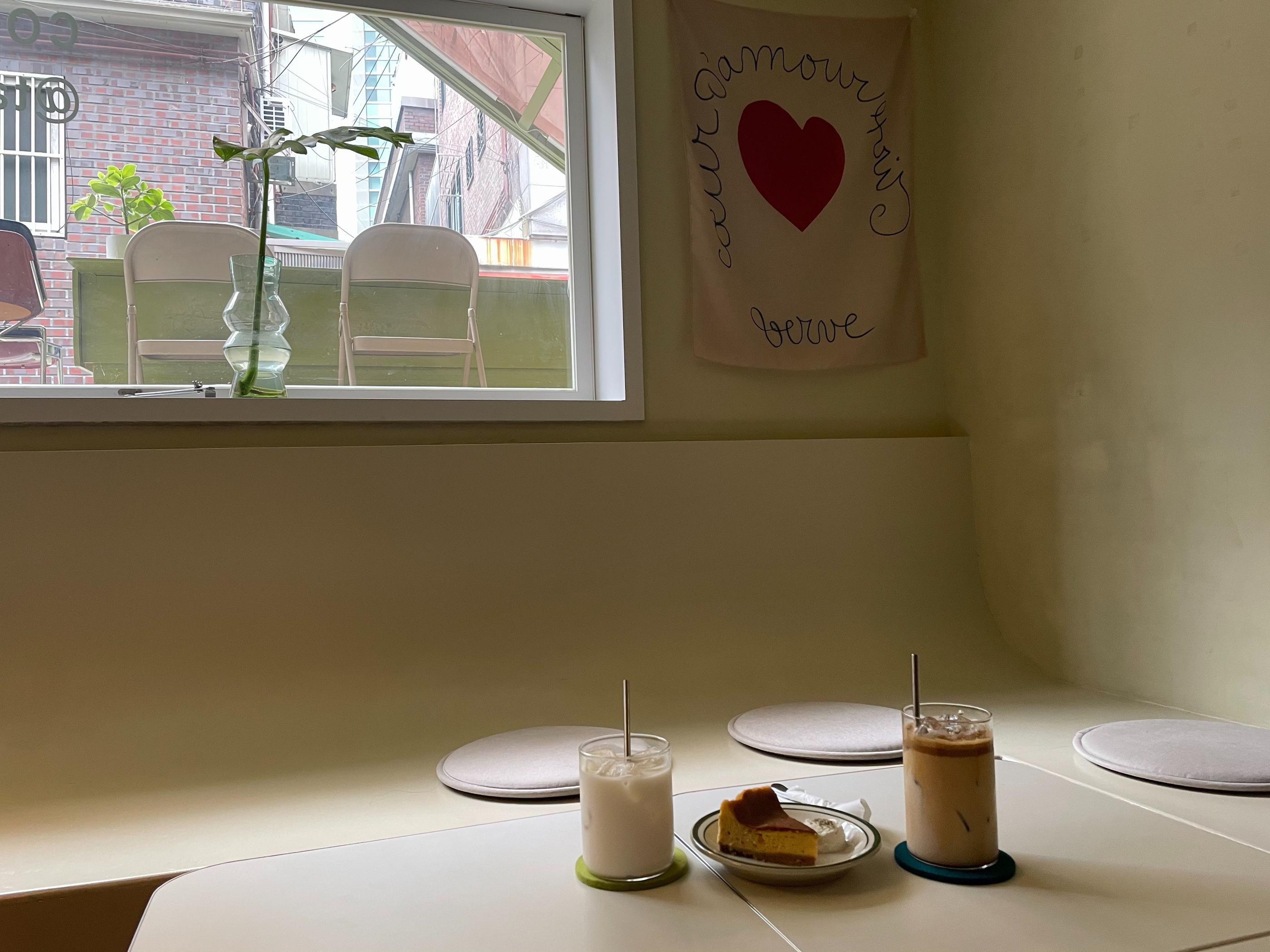 cafe talk nonsense cake, coffee and milk tea on white table by big window