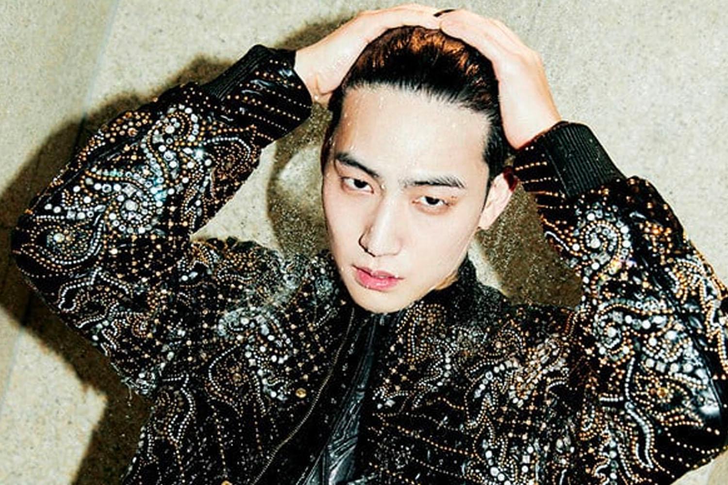 รูปภาพของศิลปินวางมือบนหัว สวมเสื้อประดับลวดลายจากนิตยสาร Arena Homme Plus