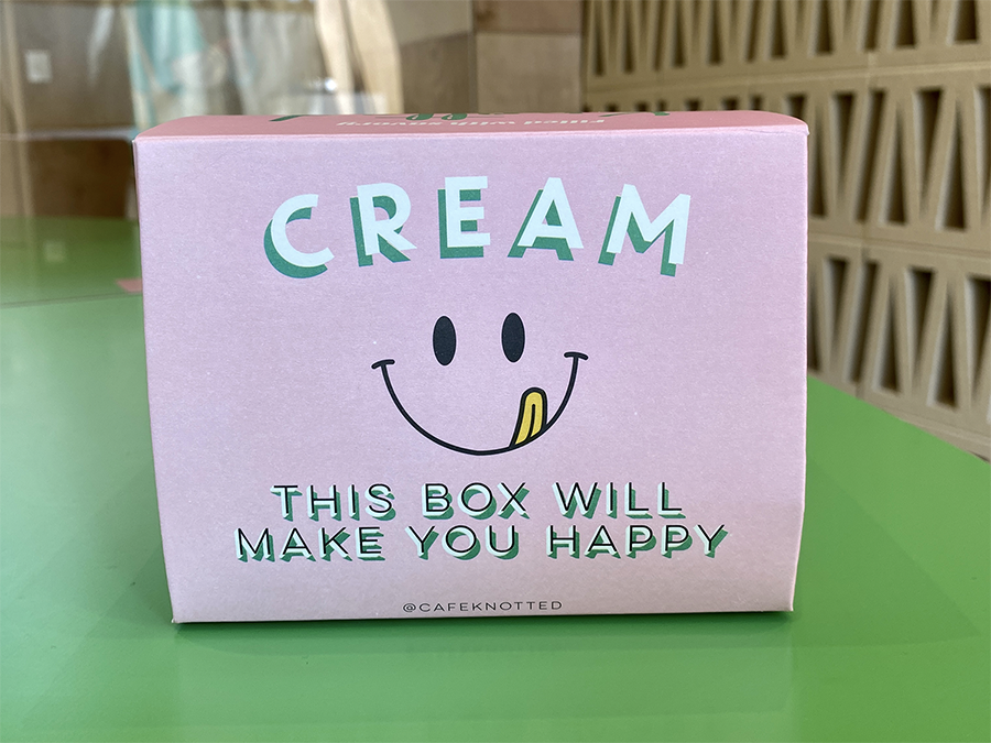可愛的粉紅色外帶包裝盒，寫著"Cream - This box will make you happy"字樣。