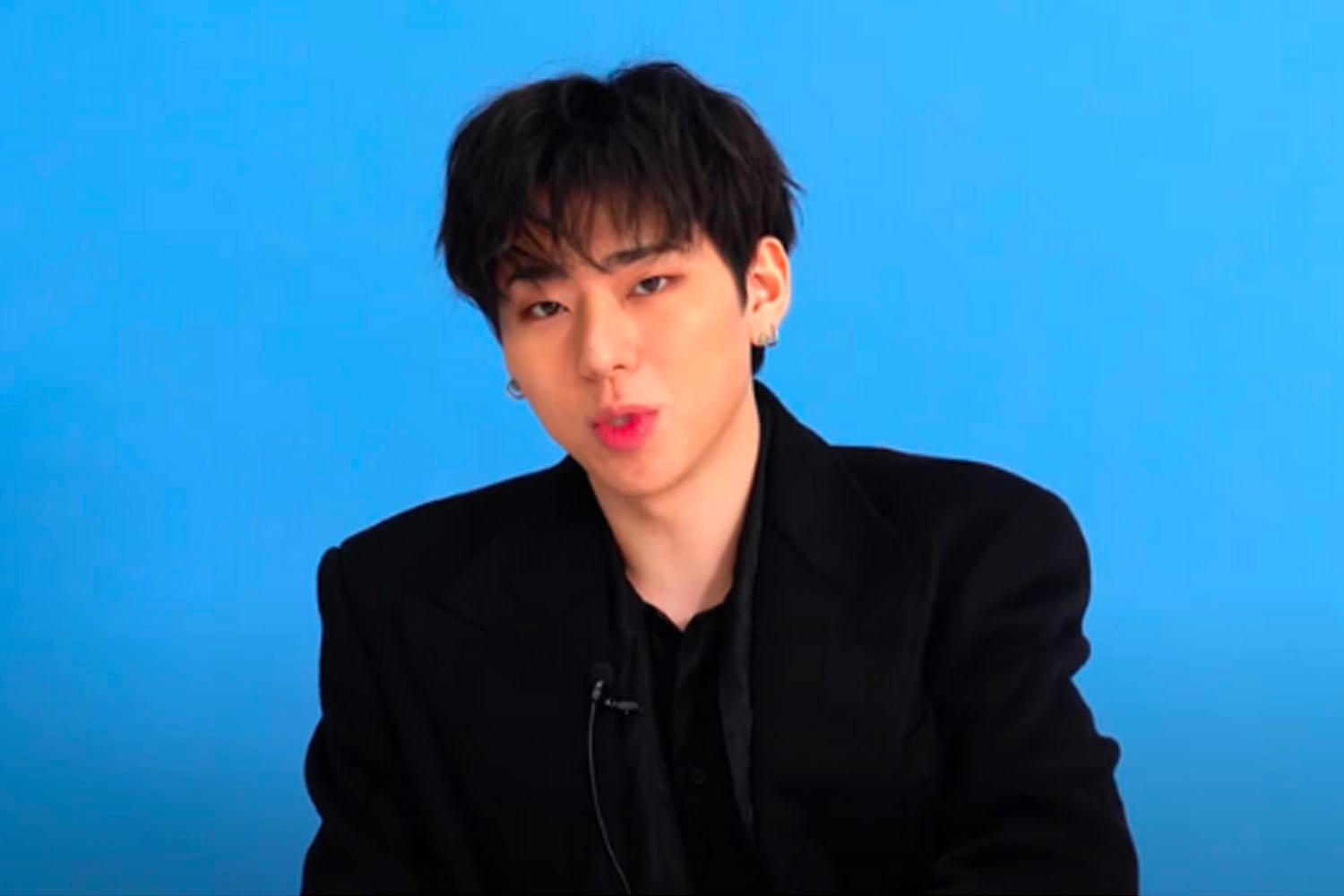 韓國雜誌 GQ Korea 的訪談中穿著黑色西裝的名人，背景為藍色