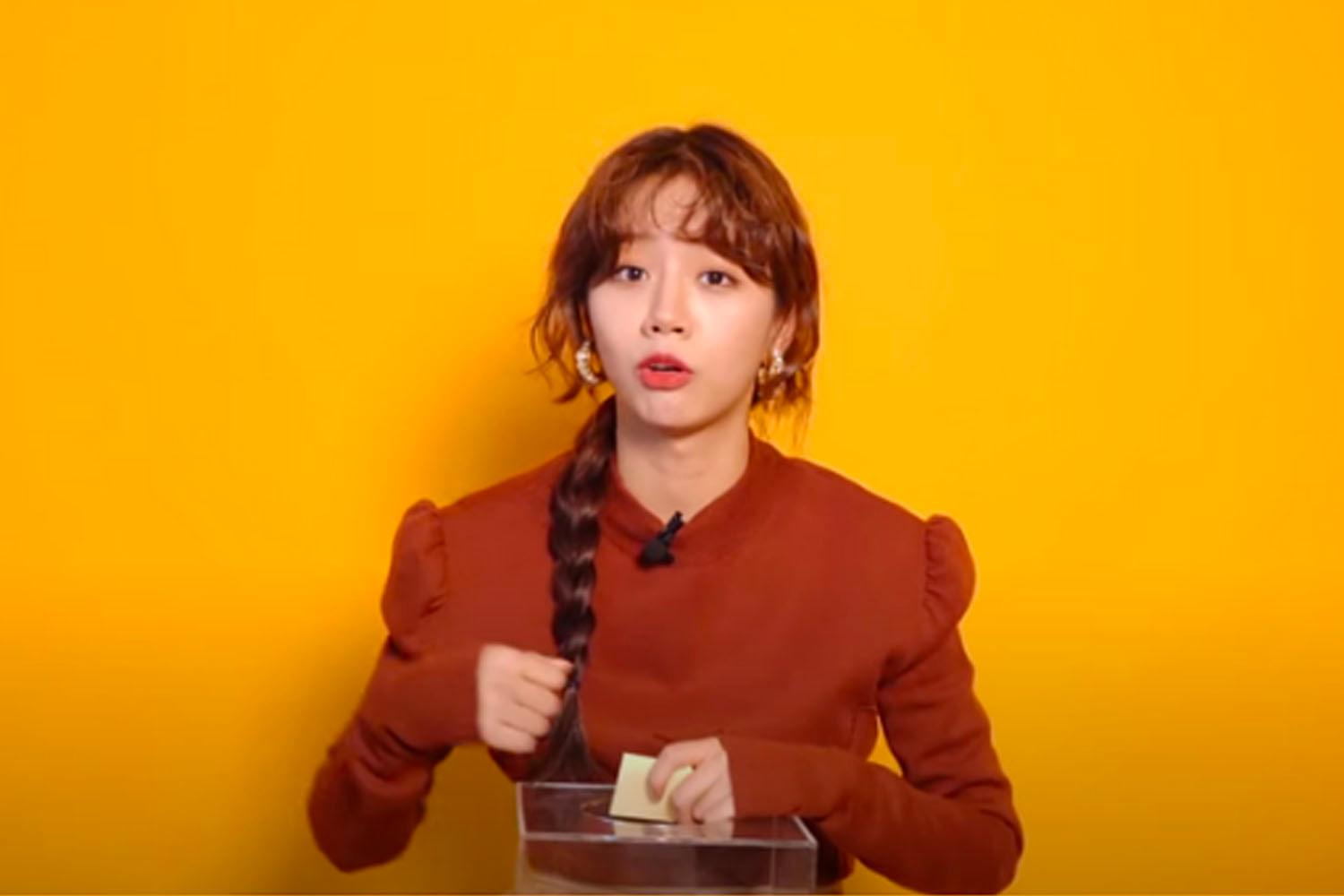 韓國雜誌 GQ Korea 的訪談中穿著橙色毛衣的名人辮子,背景為橙色