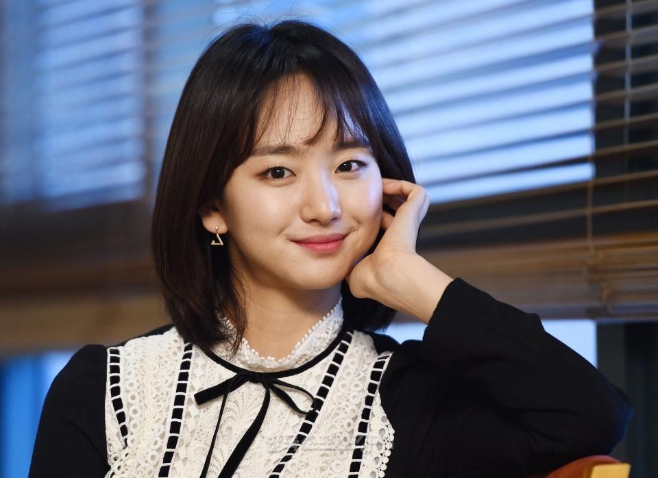 ウォン・ジナ、薄ピンクのトップを着てポーズをとるシーン