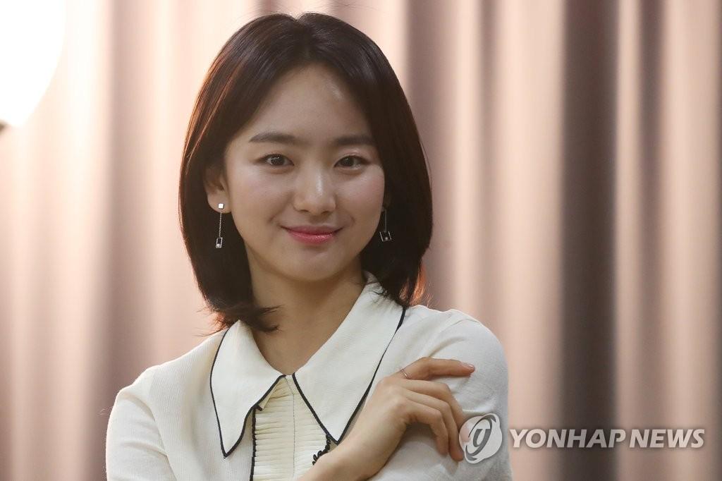 ウォン・ジナが白いブラウスを着ている