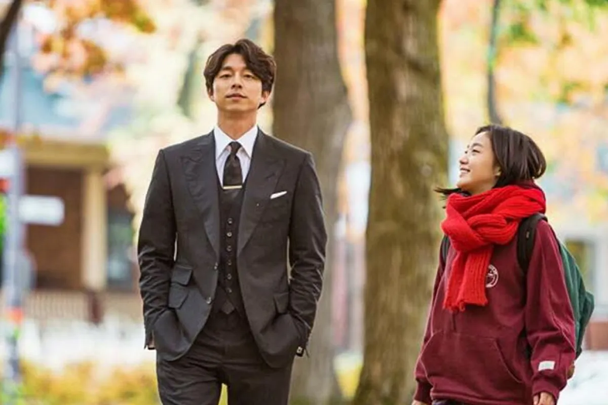 韩剧《鬼怪》剧照，西装男和围巾女角色走在秋天的校园小路上，画面充满浪漫气息