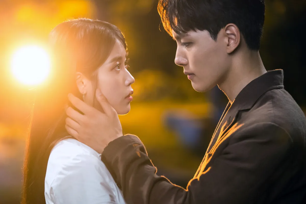 电视剧《德鲁纳酒店》中的浪漫一幕，背光下男女主深情凝视，柔和光线营造温馨氛围