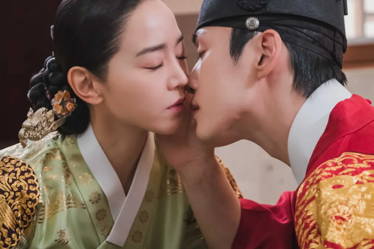 韩剧《哲仁王后》剧照，王后与大臣在皇宫内低声交谈，背景为古代宫廷