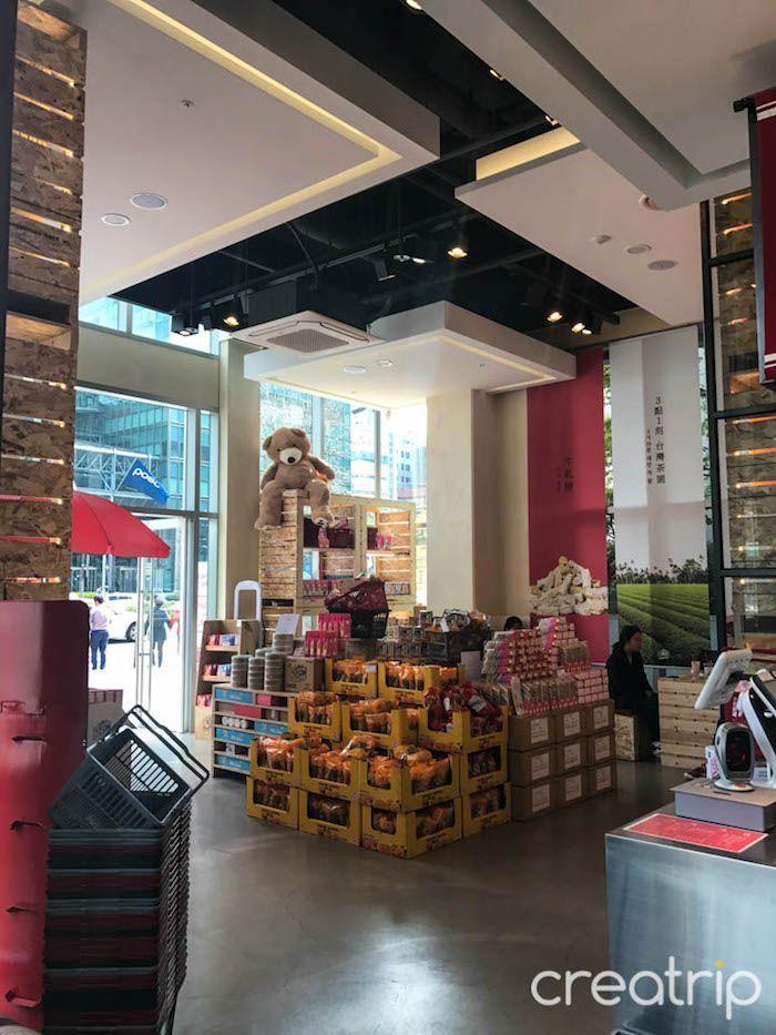 TAIWAN CAFE interior showcasing Taiwanese snacks and 3點一刻 milk tea products stacked and displayed.