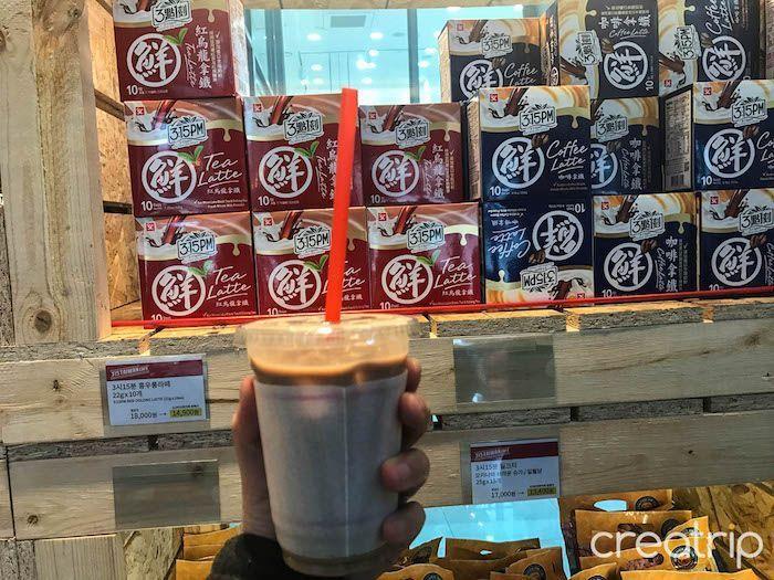 Hand holding a cup of 3點一刻 milk tea served at TAIWAN CAFE in Gangnam, Seoul.