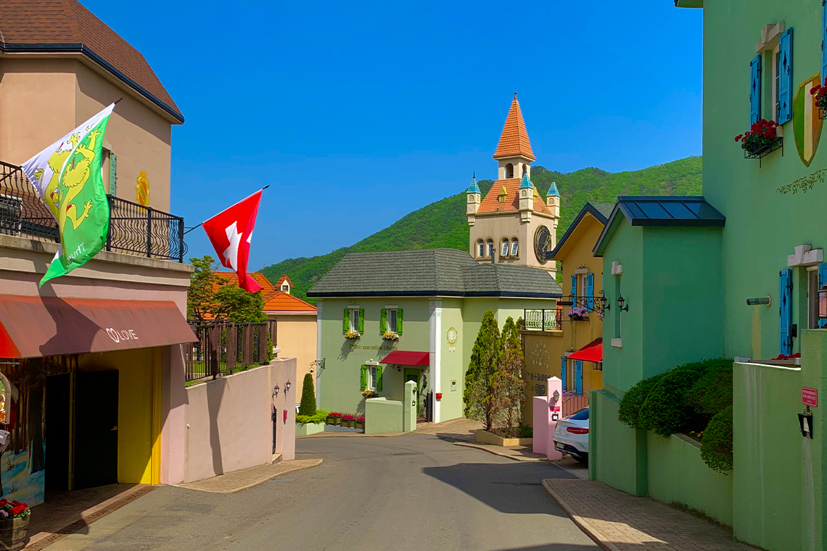 エーデルワイススイステーマパーク、カラフルな建物とスイスの旗が立つ美しい風景、京畿道加平に位置する韓国旅行の観光名所。