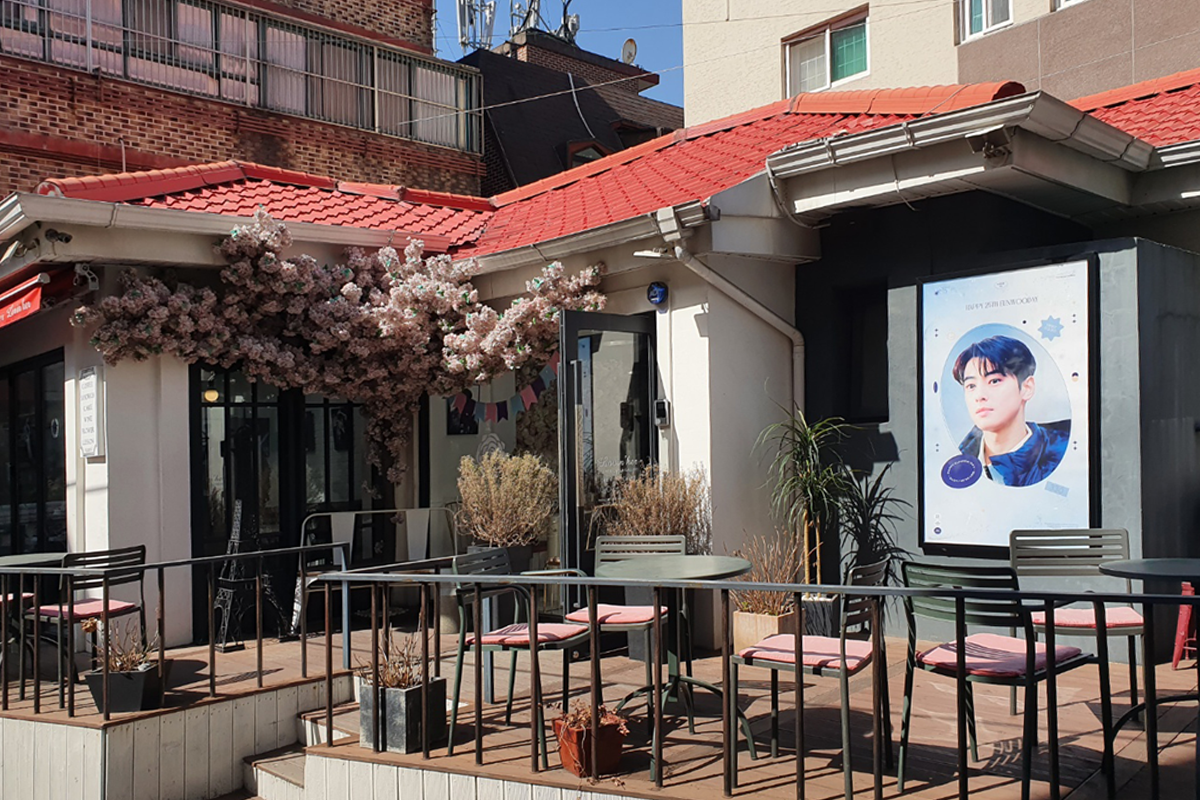 香港的生日咖啡館外觀，櫻花裝飾在建築物周圍，氣氛浪漫宜人。