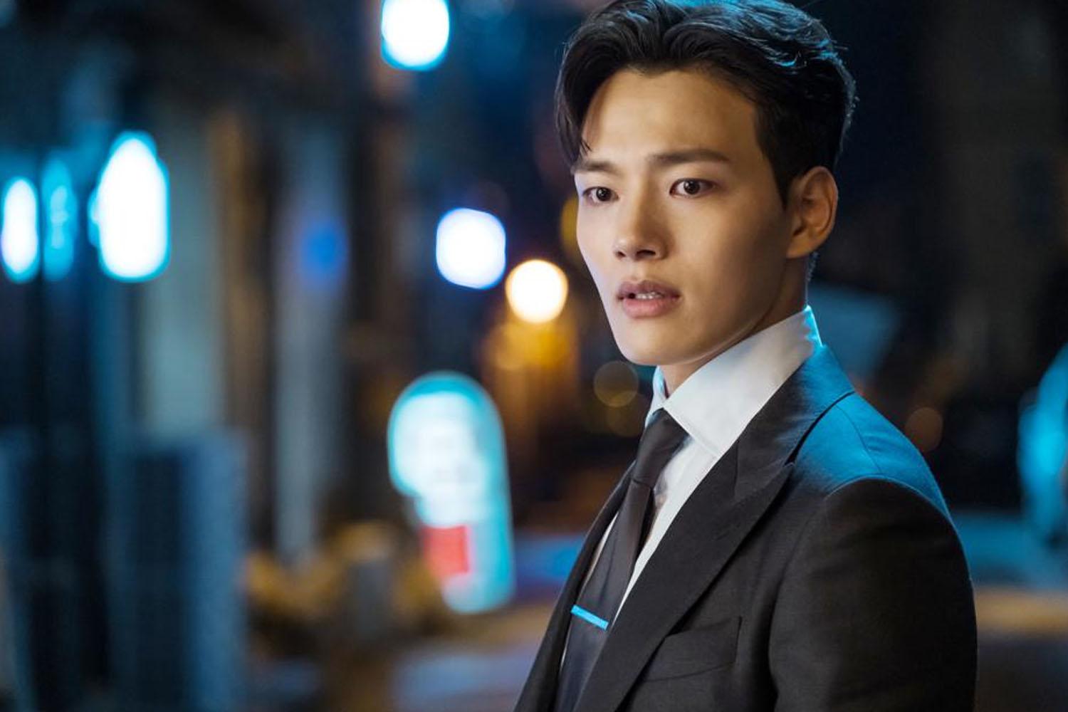 นักแสดงชายสวมชุดสูทอย่างมีสไตล์ในฉากของซีรีส์ที่ไม่ระบุตัวตน