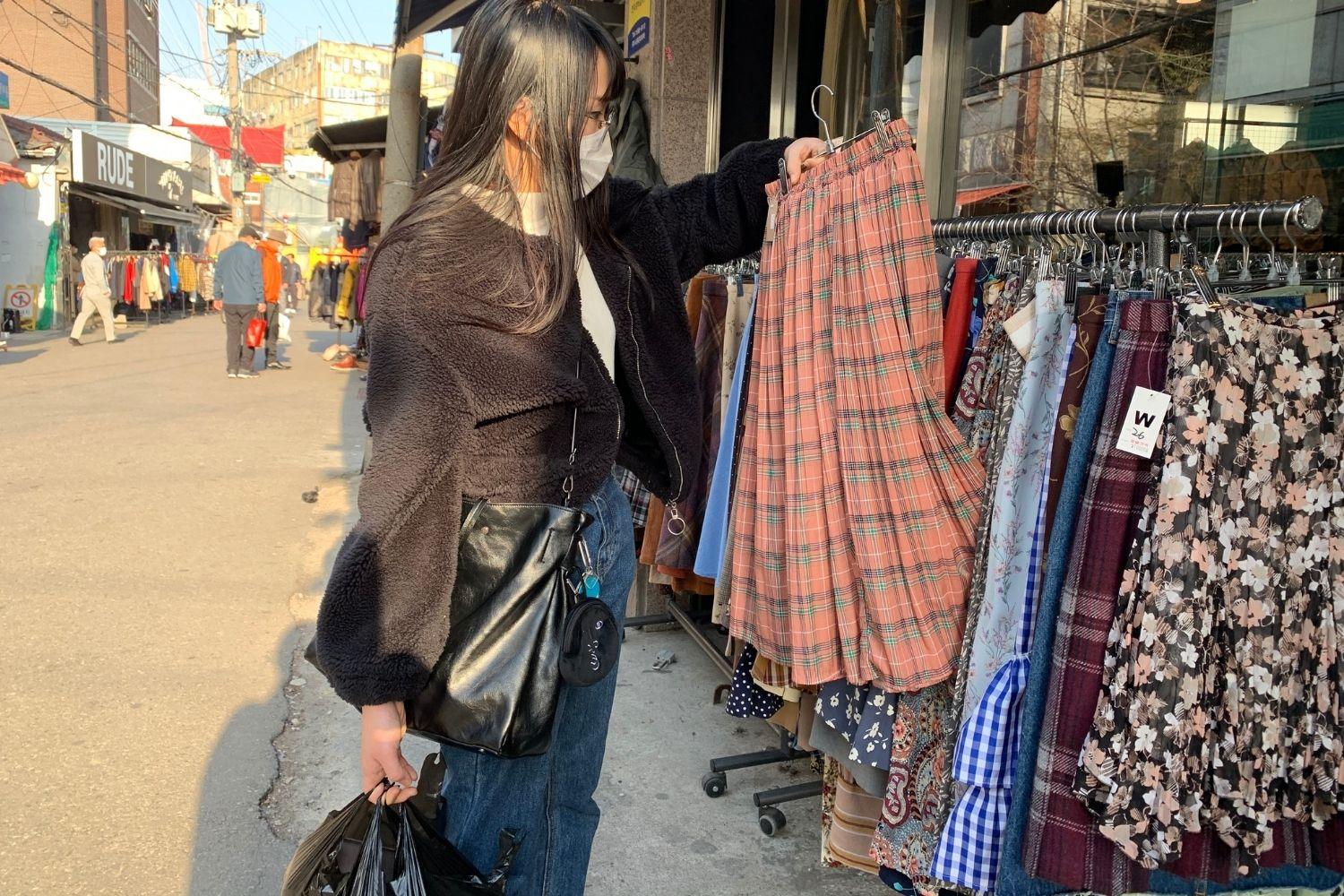 Girl holding up bright skirt at dongmyo flea market