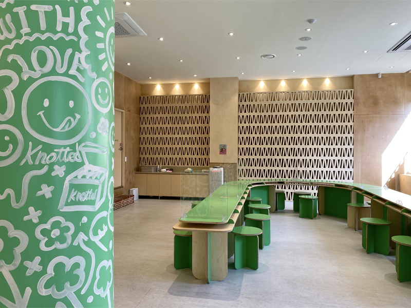 cafe knotted in samseong, seoul - inside with green pillar with white doodles, light wooden finishes