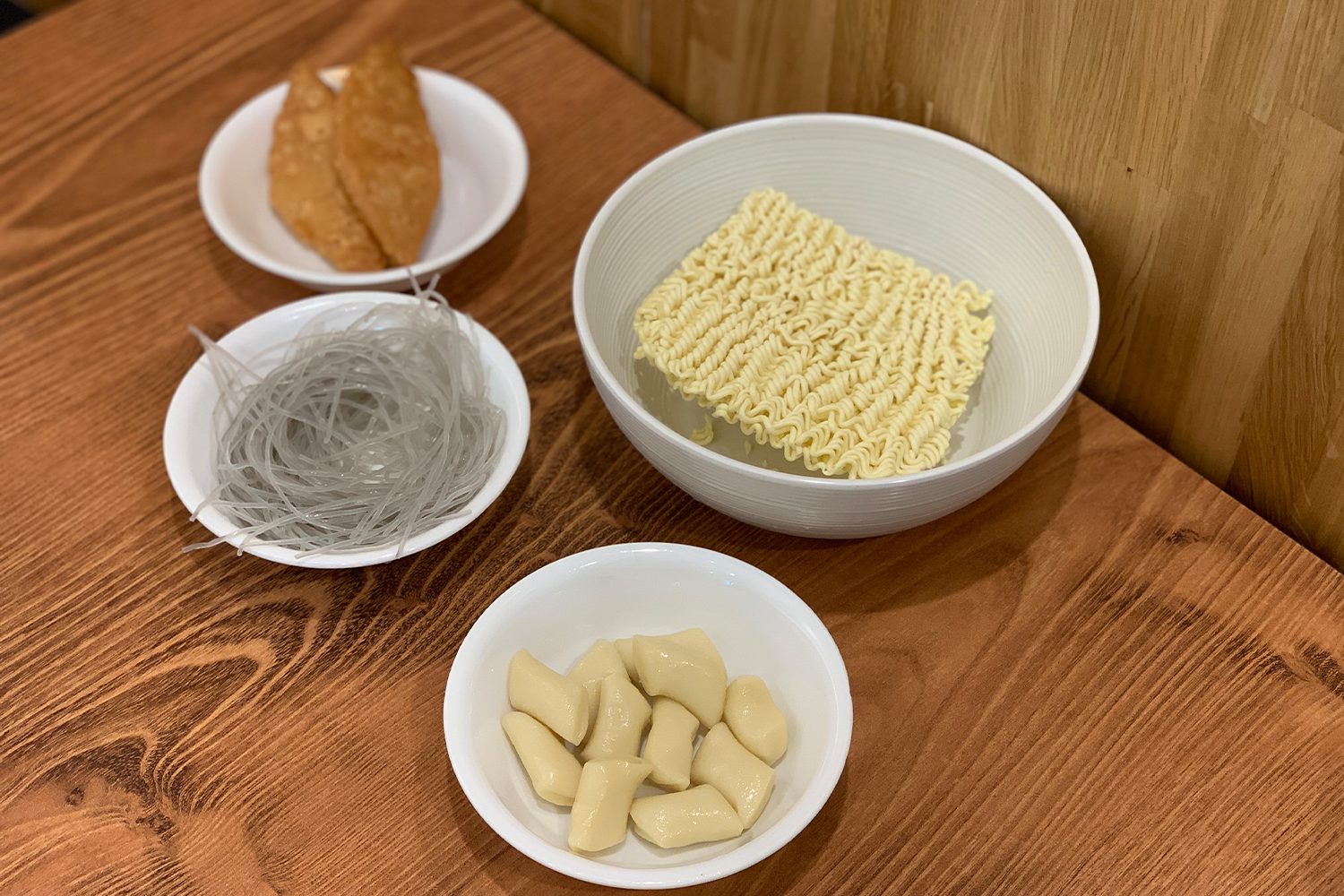 Một bộ nguyên liệu dùng kèm cho Bulbap bao gồm ramen, mì miến, và bánh xèo hàm.