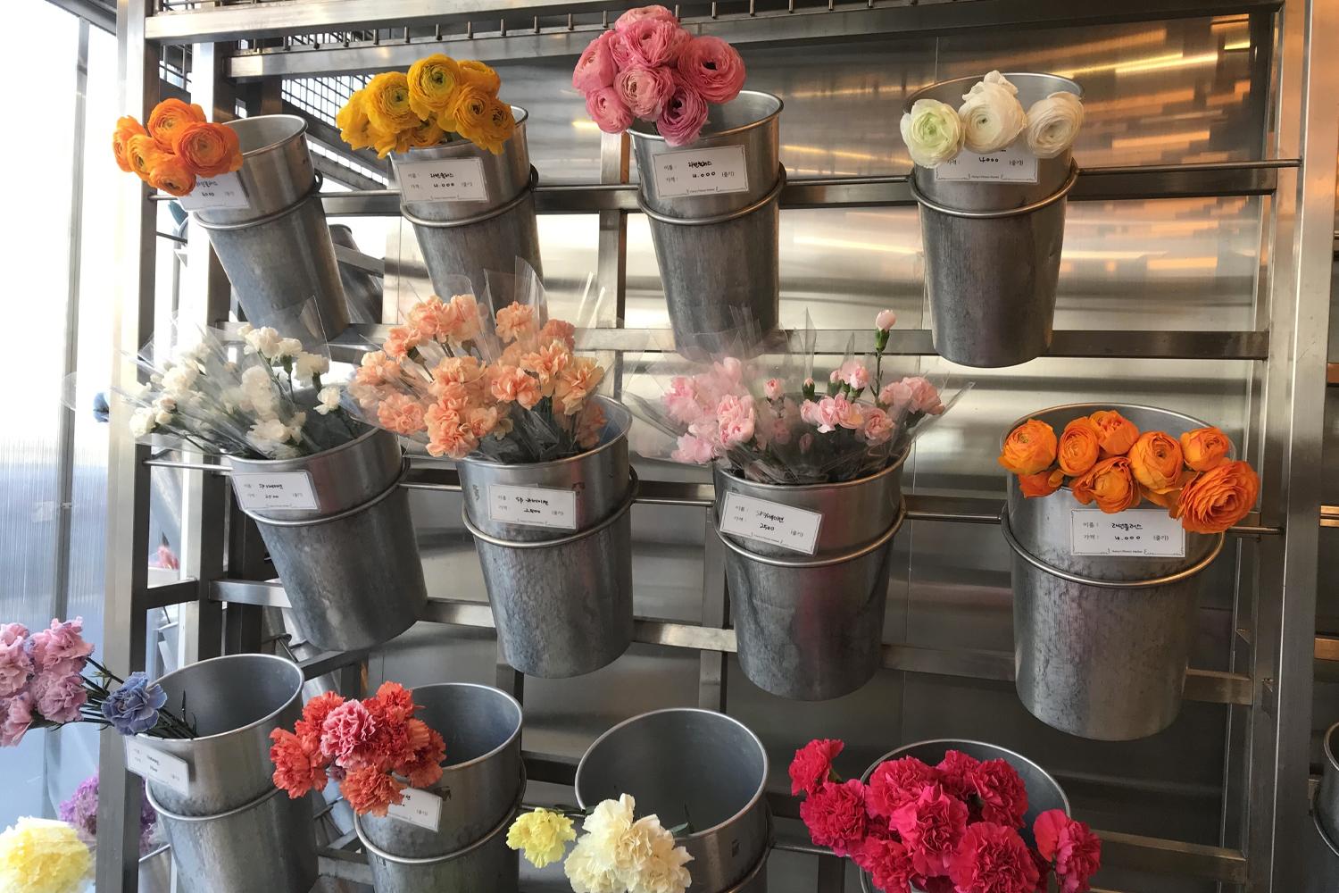 花店內多種顏色鮮花的展示，中間掛有價格標識牌