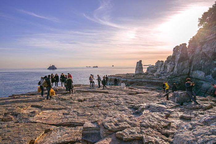 遊客們站在神仙岩上，從太宗臺俯瞰壯觀的海景和礁石。