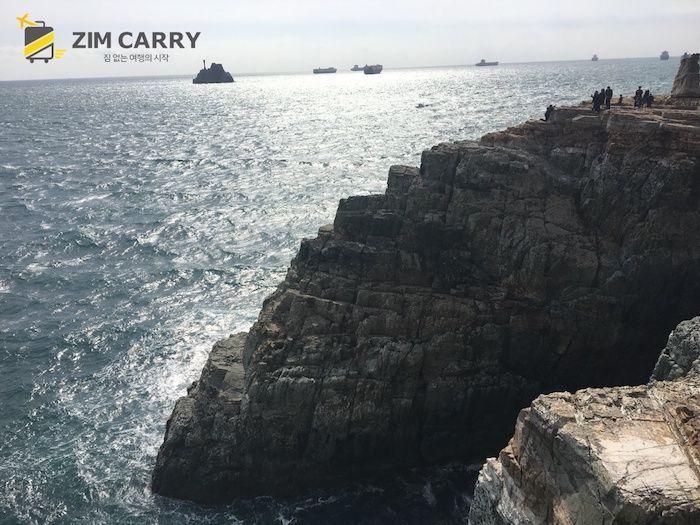 站在岩石上的旅客們，享受海風吹拂的瞬間。