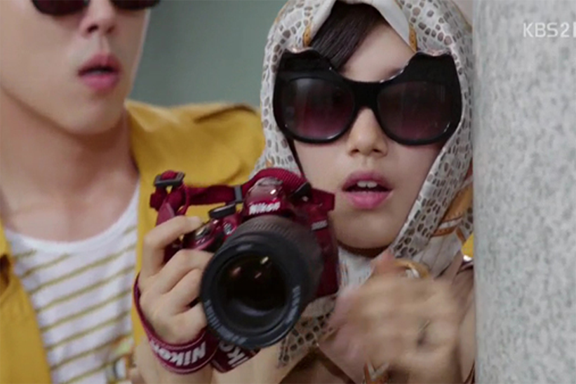 一位記者拿著相機，展示韓國用 '파파라치' 描述狗仔隊的常用詞。