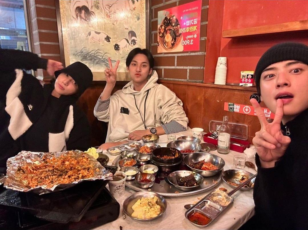 韓国の人気焼肉店で友達と食事、サムギョプサルと様々なおかずがテーブルに並んでいます。