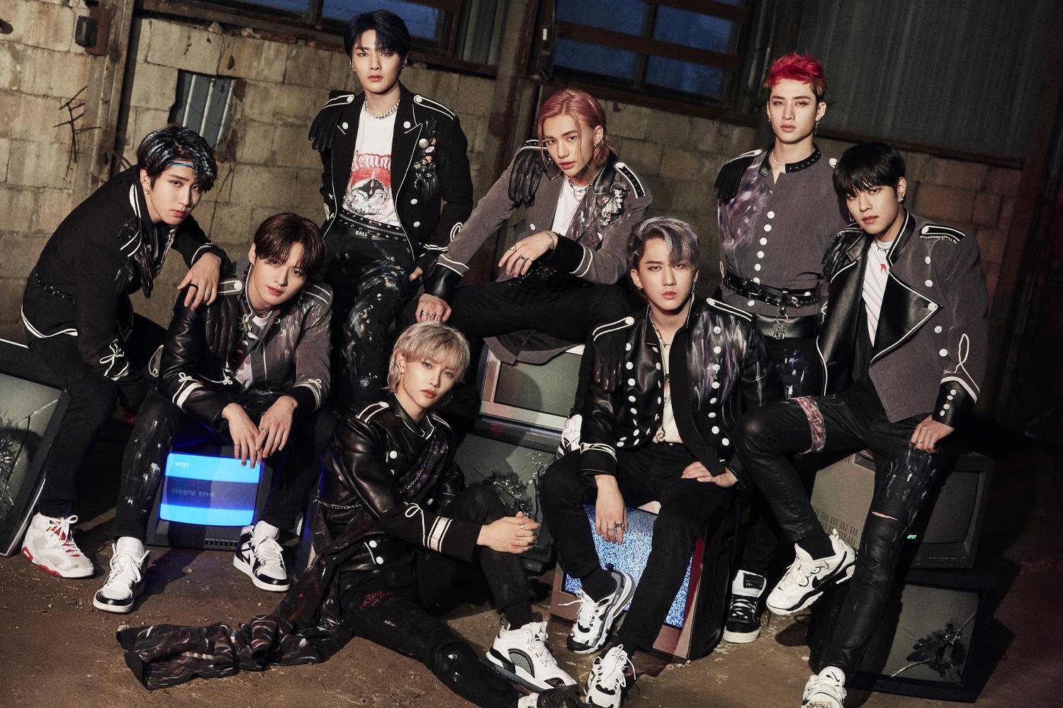 สมาชิกวง STRAY KIDS ยืนใส่ชุดเวทีนักเต้นสีดำในลวดลายสัตว์หรูหรา