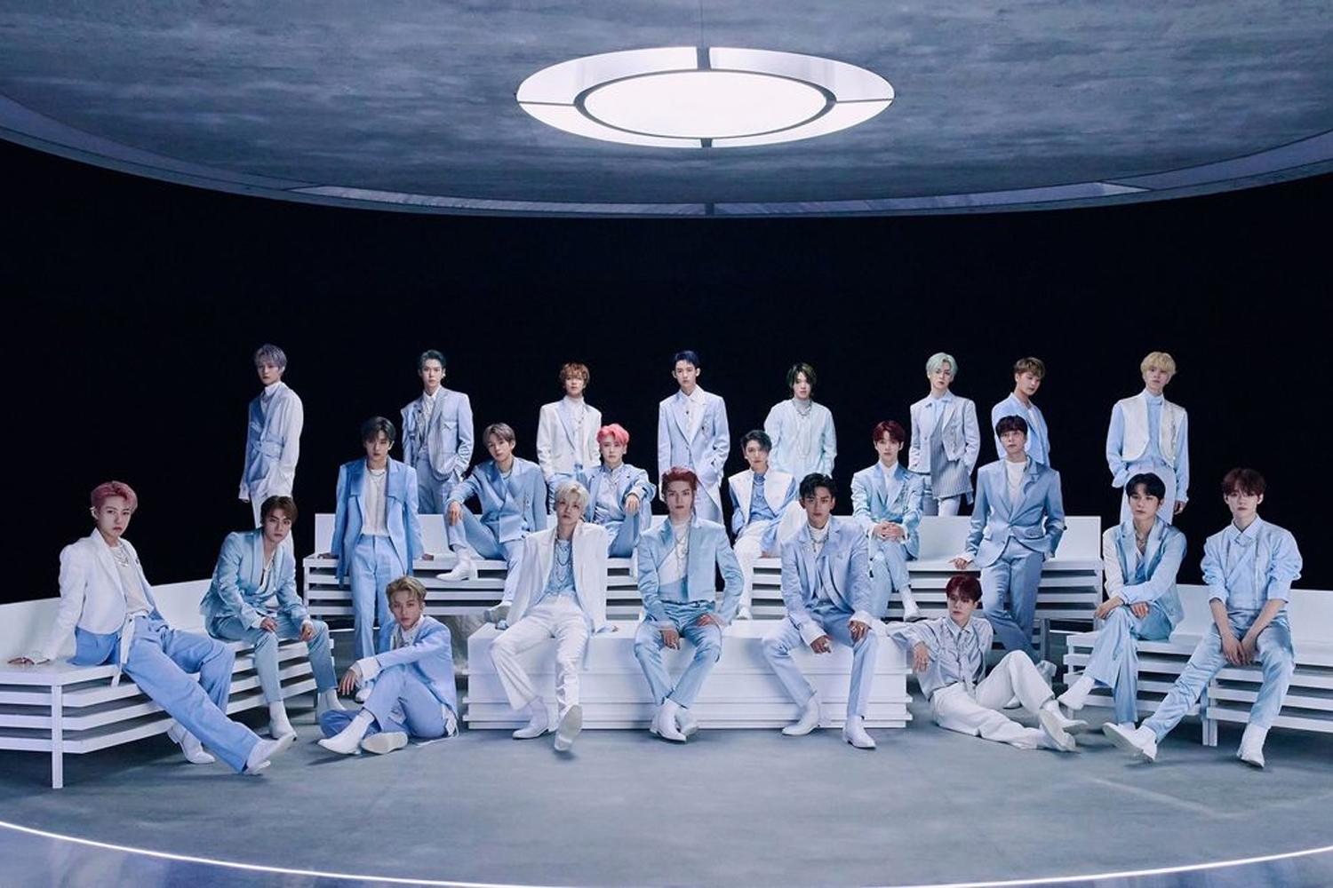 วง NCT ถ่ายภาพหมู่ร่วมกันในเสื้อสูทสีฟ้าภายใต้แสงไฟบนเวทีใหญ่