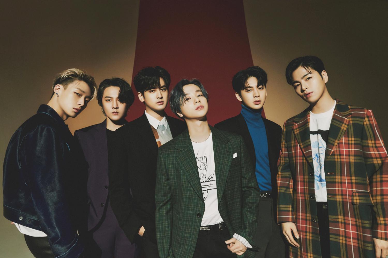 วง iKON ในชุดกางเกงสีเข้มและเสื้อสุดเท่ห์ยืนอยู่ภายในห้องตอกไม้หรูหรา