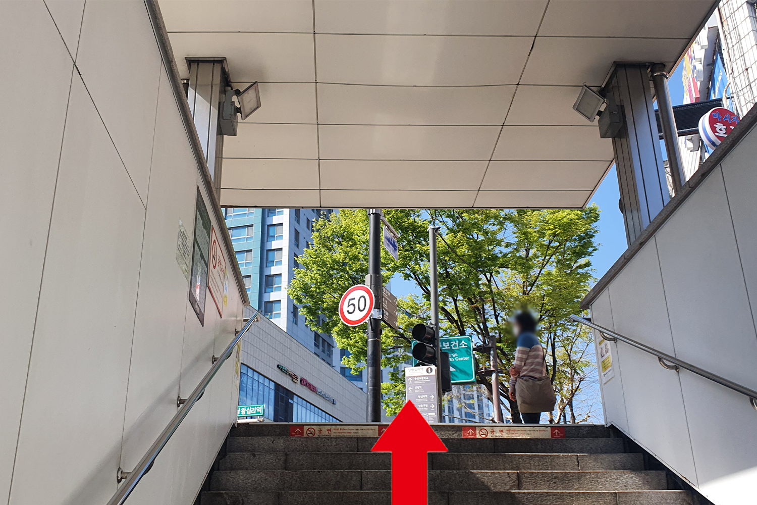 Ingresso della stazione Sangwangsimni a Seoul, Corea del Sud, con freccia rossa che indica la direzione del caffè PAINT.