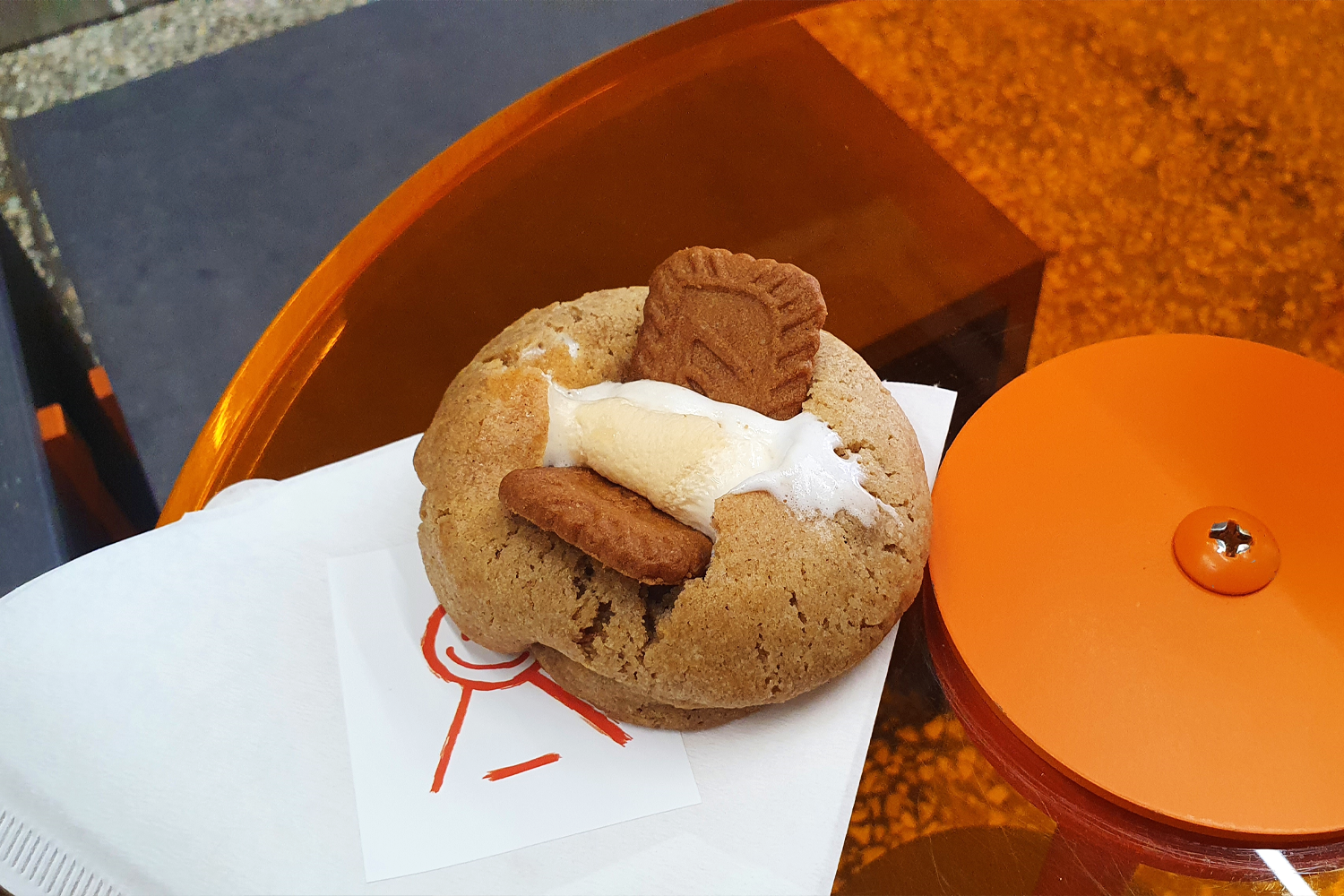 手部擁握橙色主題飲品，展示Arkofbrothers咖啡廳的獨特飲品設計。