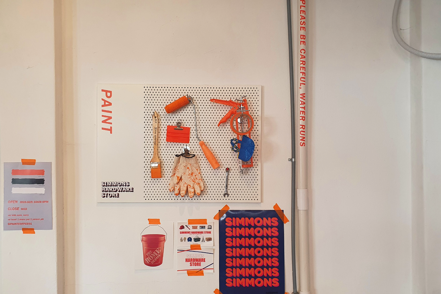 paint supplies hanged up as decor against a white wall at paint cafe